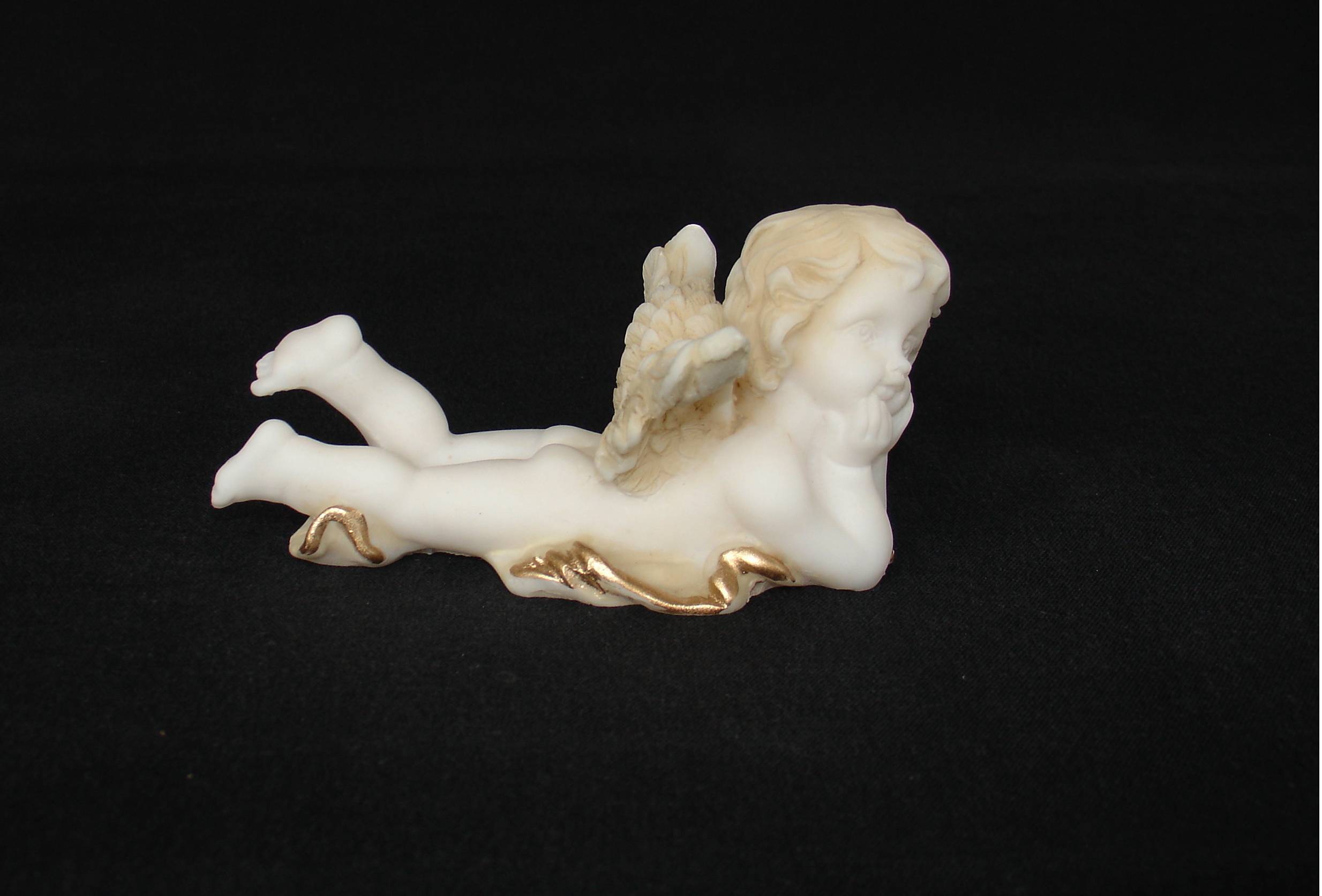 Lying angel holds his head statue