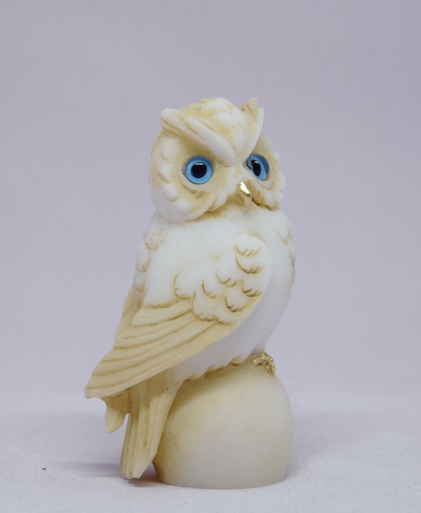 Owl sitting on a sphere statue — image 5