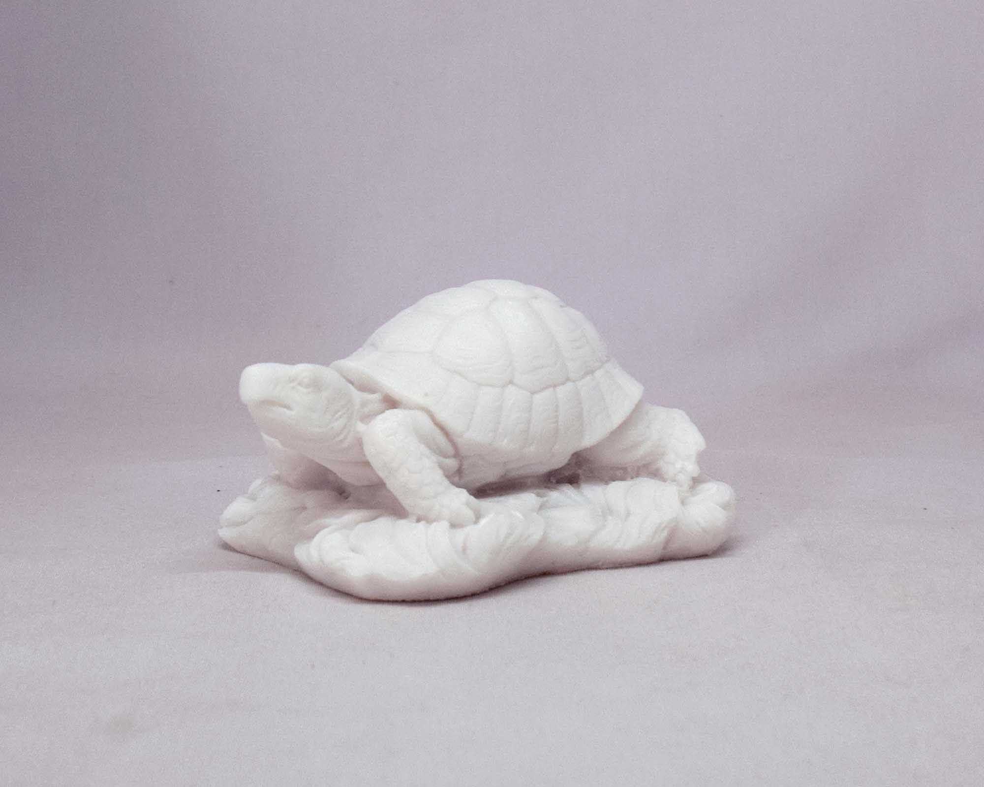 Turtle statue on sand — image 2